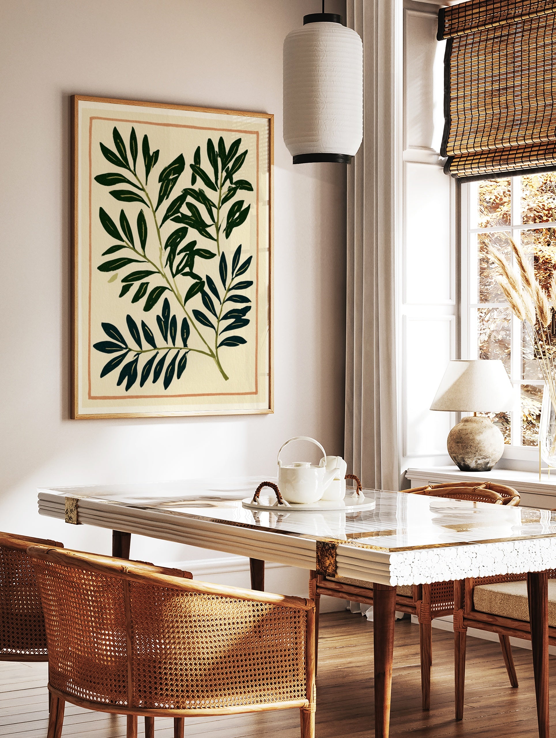Botanical leaf print with deep green foliage and thin orange border on cream paper background, in a styled room mockup