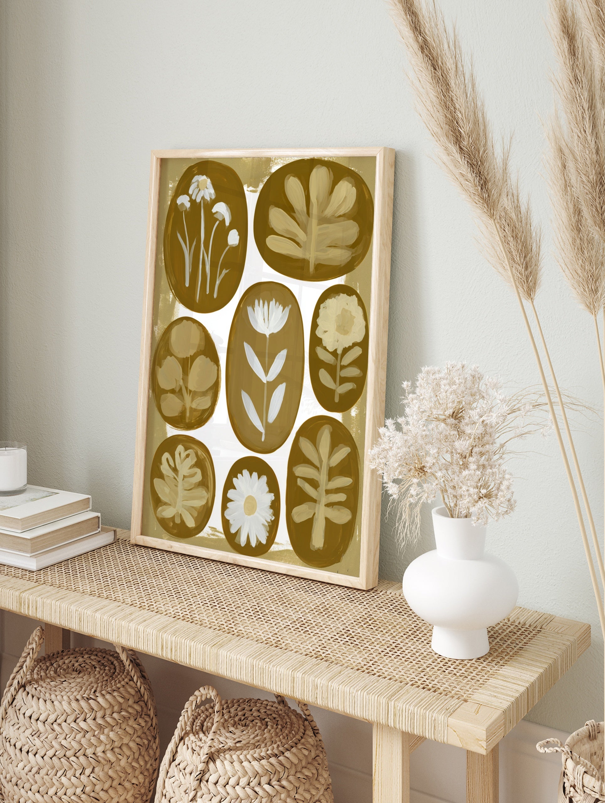 Botanical wall art print with eight oval floral and leaf illustrations in white against a, in an alternate framed mockup