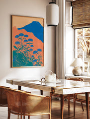 Illustrative botanical wall art with blue flowers, green leaves, orange hills, and a blue mountain under a light orange sky. - Image 2