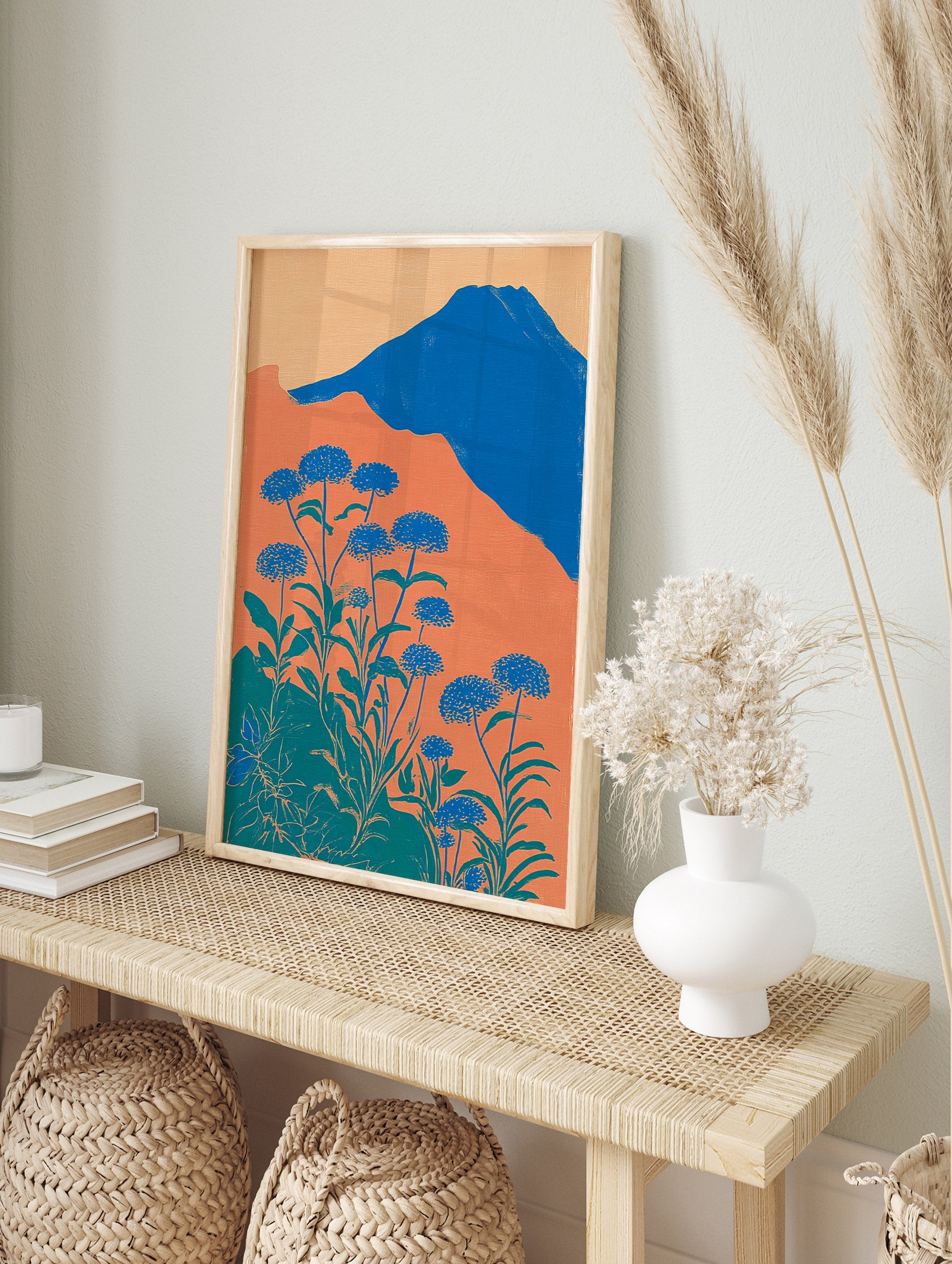 Illustrative botanical wall art with blue flowers, green leaves, orange hills, and a blue mountain under a light orange sky. - Image 3