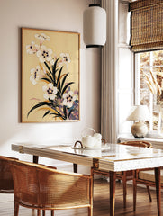 Botanical illustration of white flowers with dark centres and green leaves on a tan background, in a styled room mockup