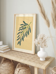Botanical willow branch illustration with green leaves and pink accents on a tan paper, in an alternate framed mockup