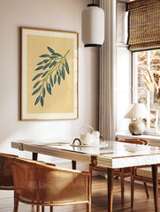 Botanical willow branch illustration with green leaves and pink accents on a tan paper background, in a styled room mockup
