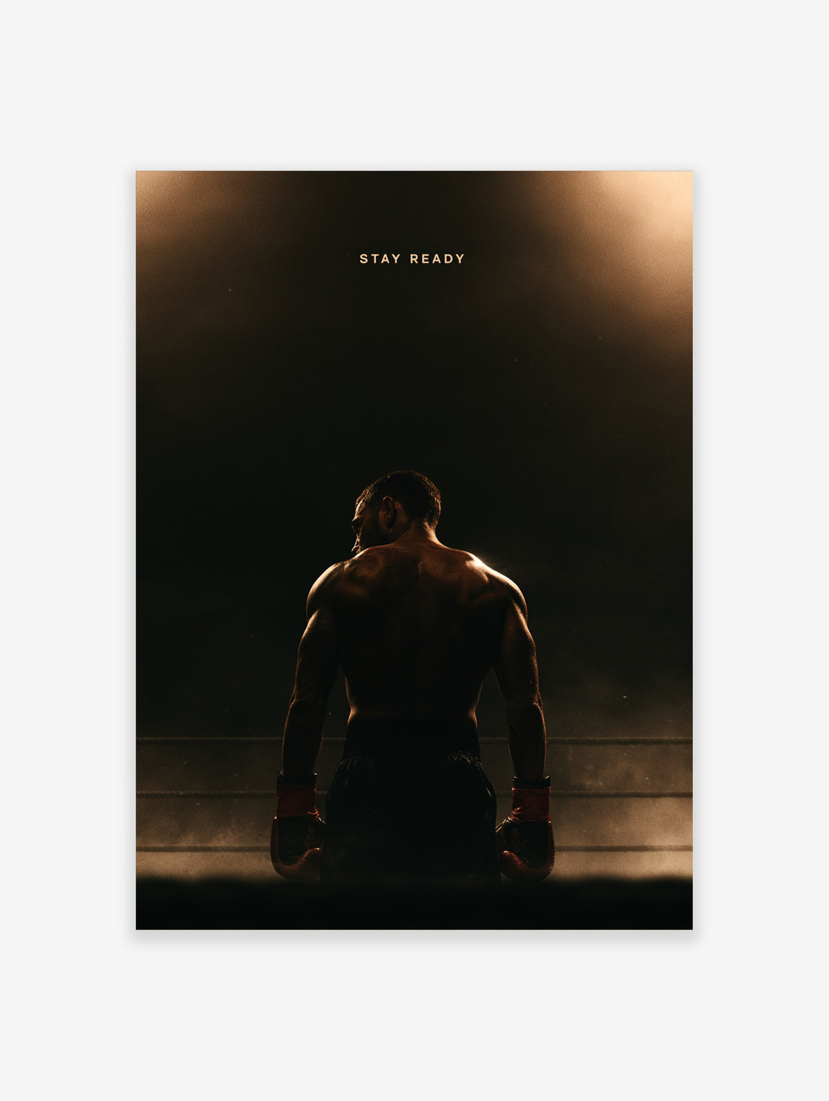 Boxer in red gloves facing away under a spotlight in a dark ring, with Stay Ready text above