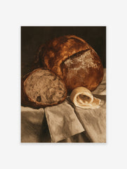 Still life wall art print of a crusty loaf of bread, a slice, and a curl of butter on draped fabric in sepia tones