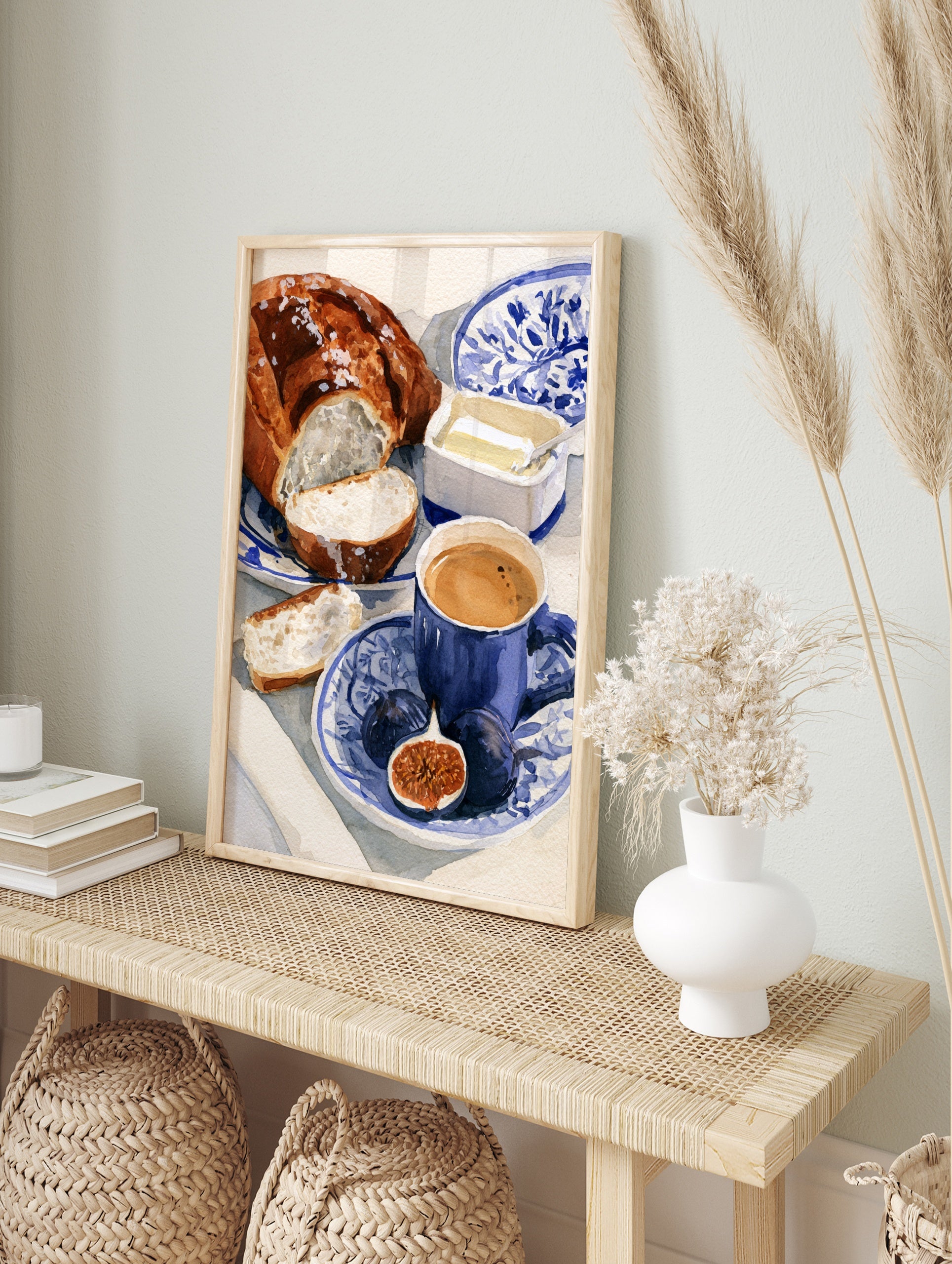 Watercolour illustration of a breakfast scene with bread, figs, and coffee on a blue and, in an alternate framed mockup