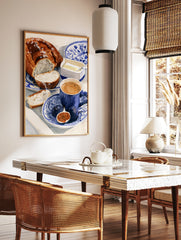 Watercolour illustration of a breakfast scene with bread, figs, and coffee on a blue and white, in a styled room mockup