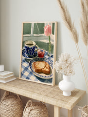Watercolour-style still life illustration of coffee, toast, jam, and a pink tulip on a blue, in an alternate framed mockup