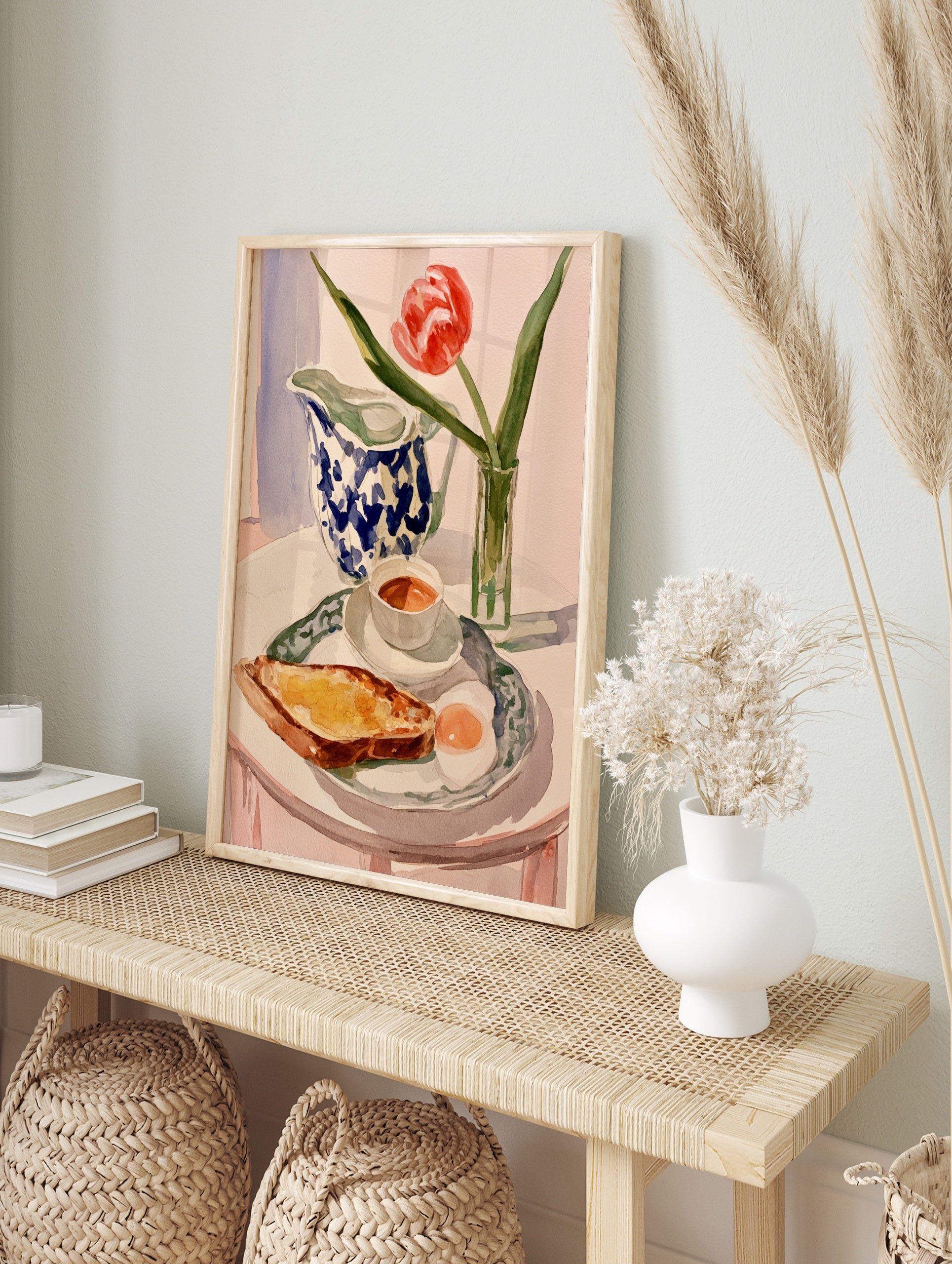 Watercolor painting of a breakfast table with a red tulip, blue-and-white jug, toast, and egg, in an alternate framed mockup