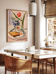 Watercolor painting of a breakfast table with a red tulip, blue-and-white jug, toast, and egg on a, in a styled room mockup