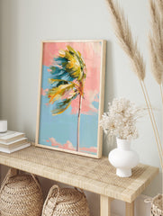 Impressionistic palm tree with green and yellow leaves blowing left against a pink and blue, in an alternate framed mockup