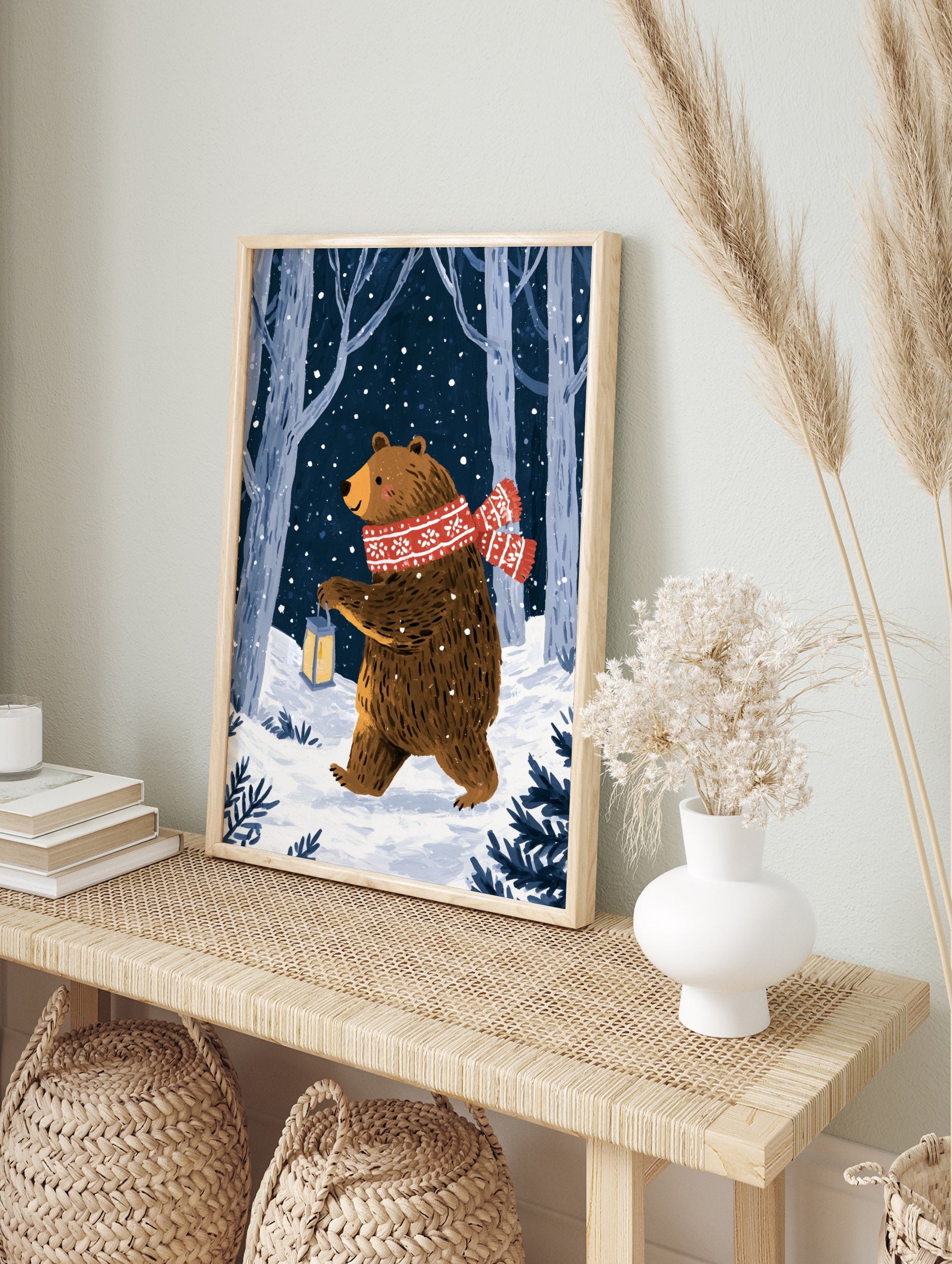 Illustrative print of a brown bear with a red scarf and lantern in a snowy forest at night, in an alternate framed mockup