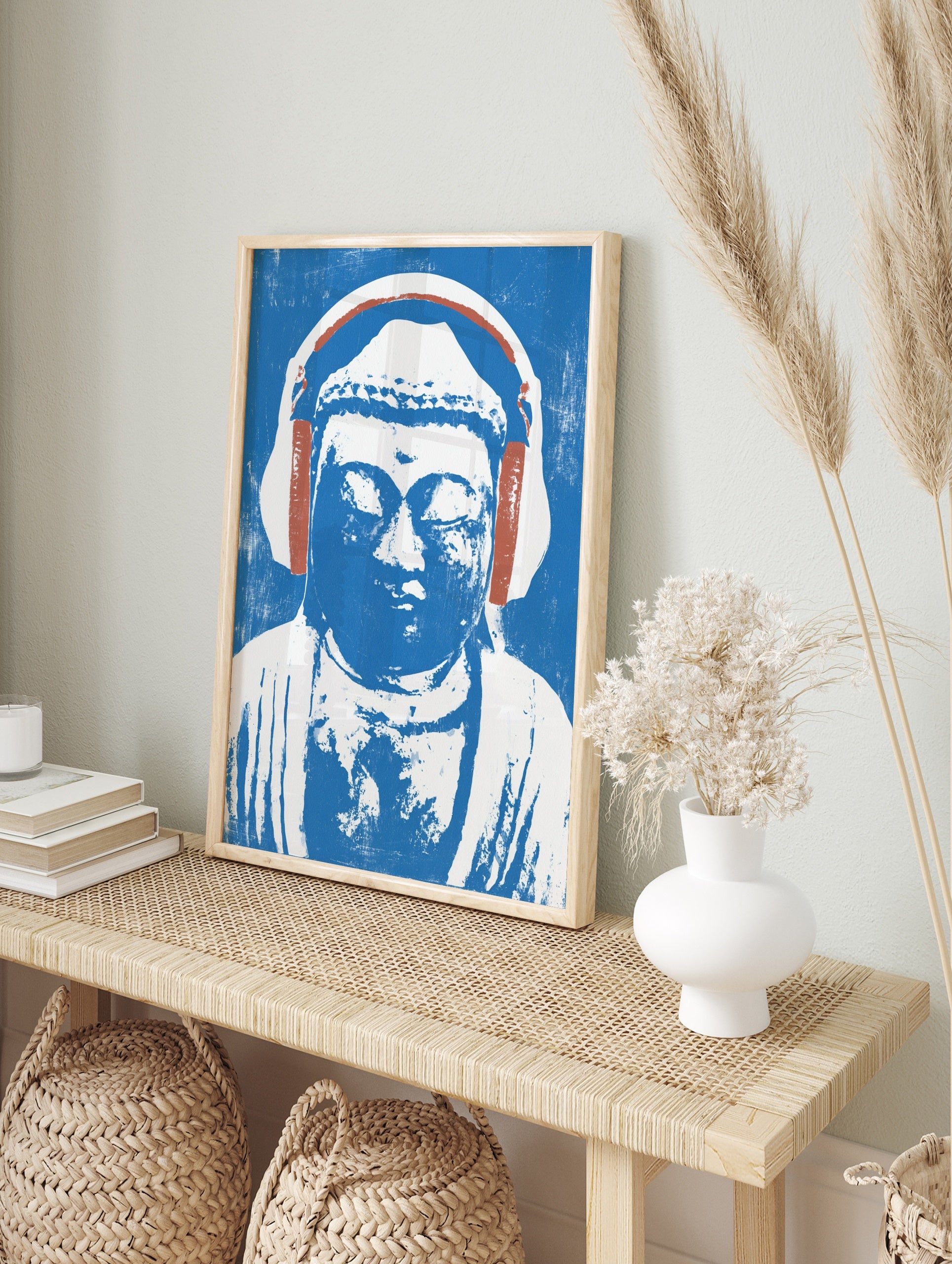 Illustrative print of a Buddha statue wearing headphones in blue and white on a textured, in an alternate framed mockup