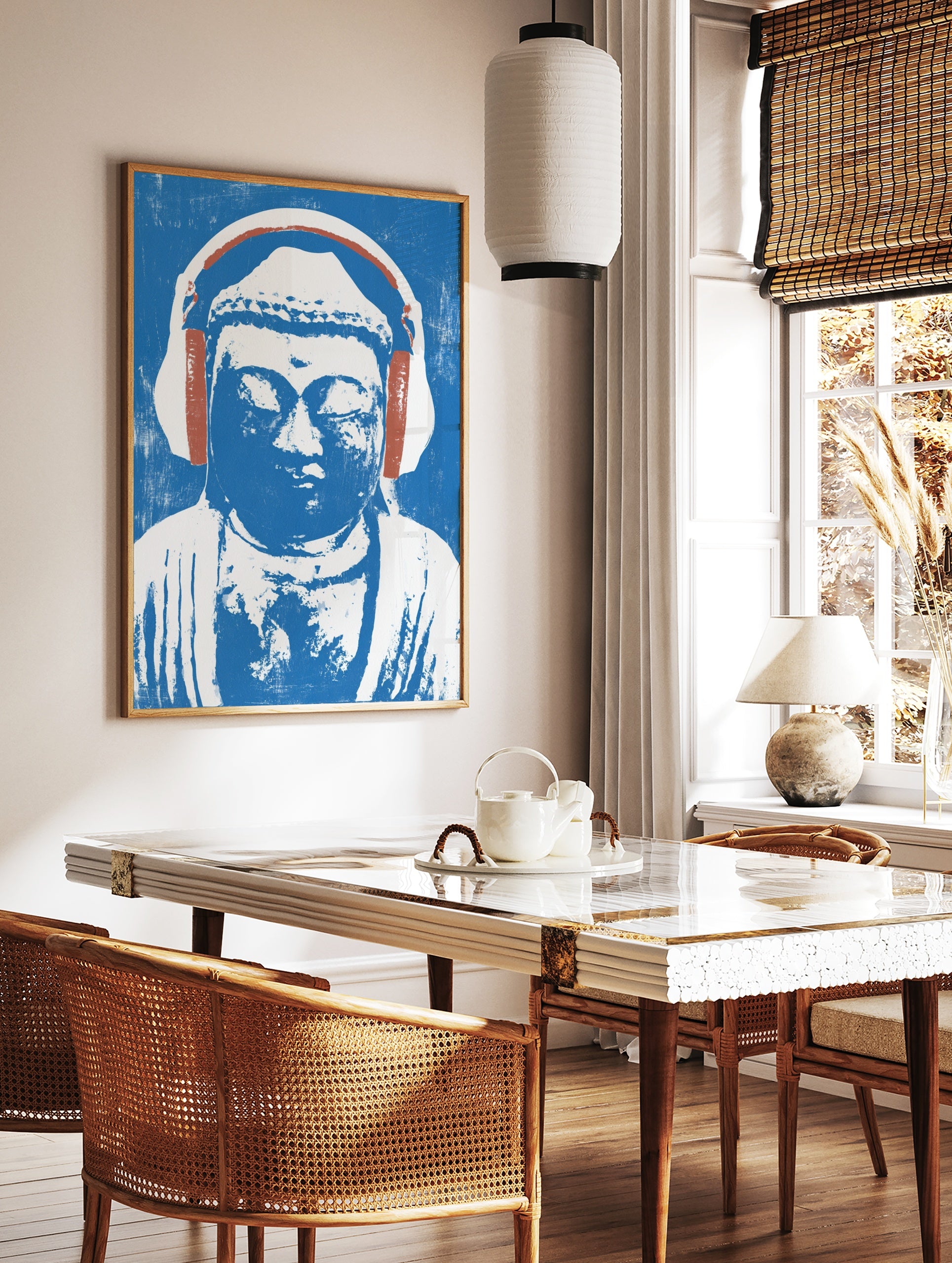Illustrative print of a Buddha statue wearing headphones in blue and white on a textured background, in a styled room mockup