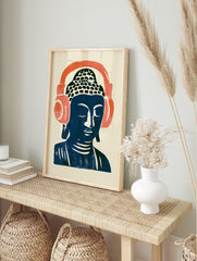 Stylized Buddha head illustration wearing large coral headphones on a cream background, in an alternate framed mockup