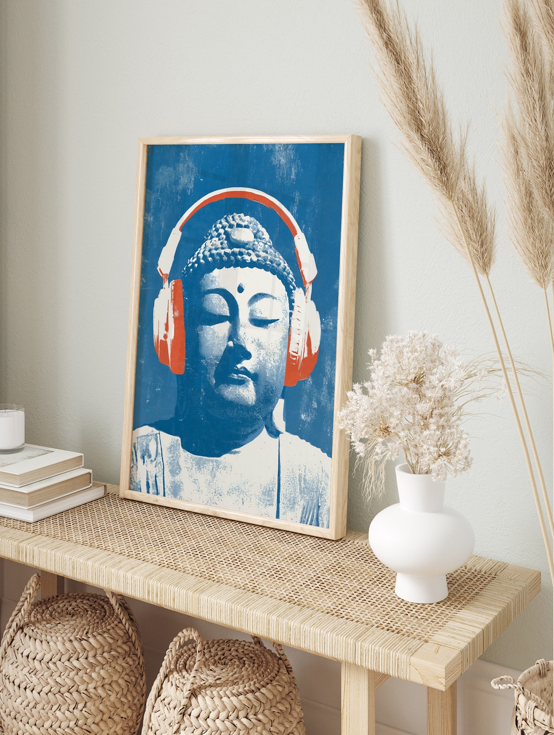 Buddha head illustration wearing large orange headphones on a textured blue background, pop, in an alternate framed mockup