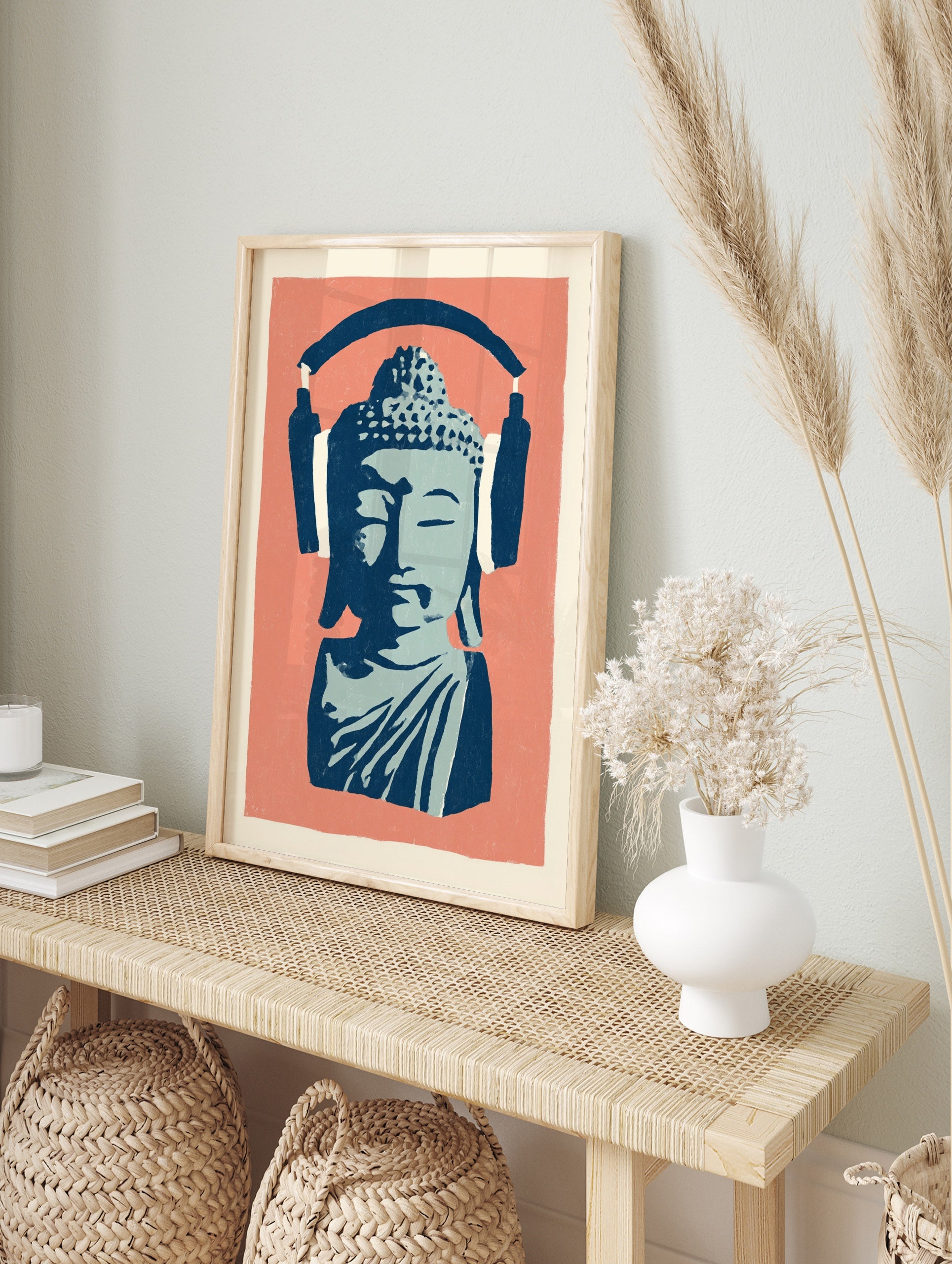 Stylised blue Buddha bust wearing large navy headphones on a coral pink background, in an alternate framed mockup