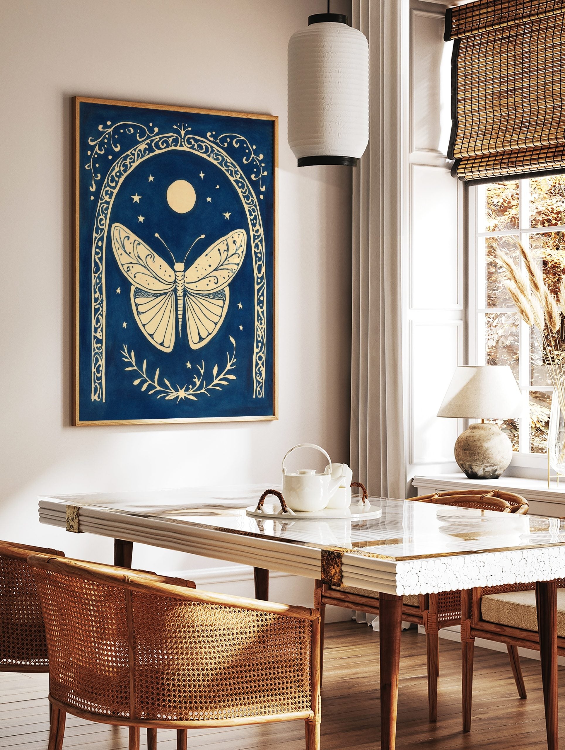 Ornate cream butterfly within a decorative arch, with moon and stars on a deep blue background, in a styled room mockup