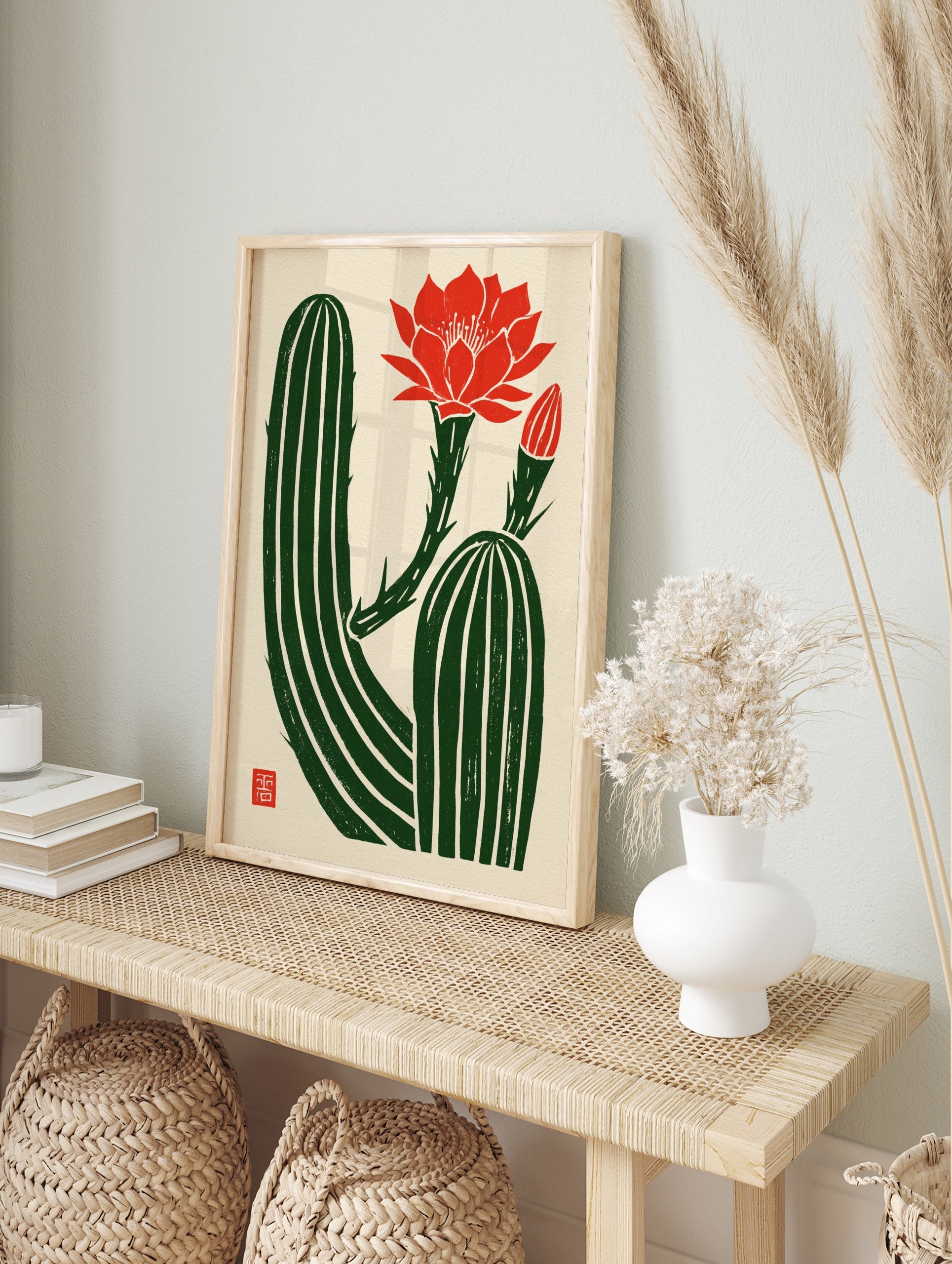 Illustrative cactus wall art with a vibrant red flower and bud on a textured cream background, in an alternate framed mockup