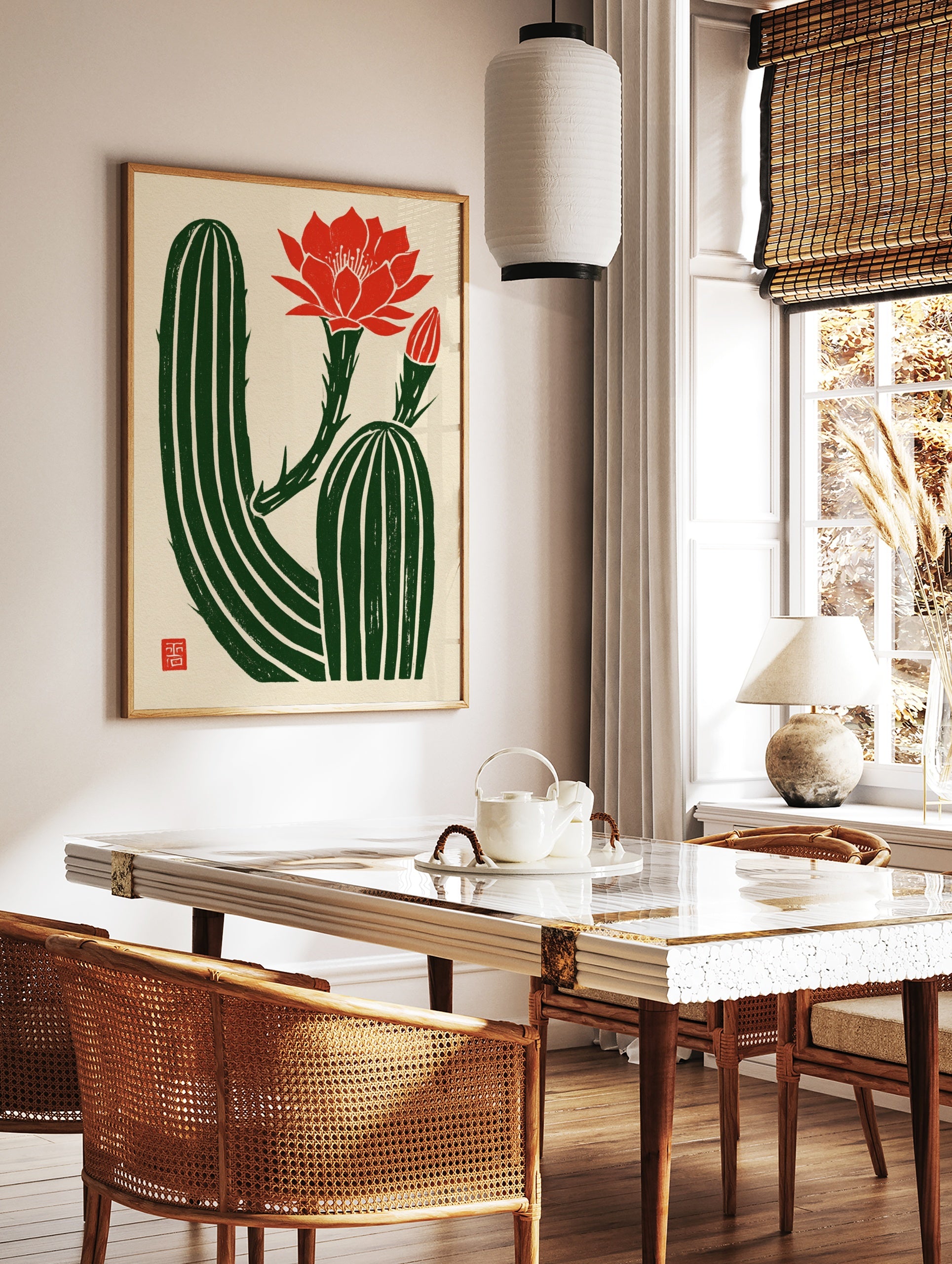 Illustrative cactus wall art with a vibrant red flower and bud on a textured cream background with, in a styled room mockup