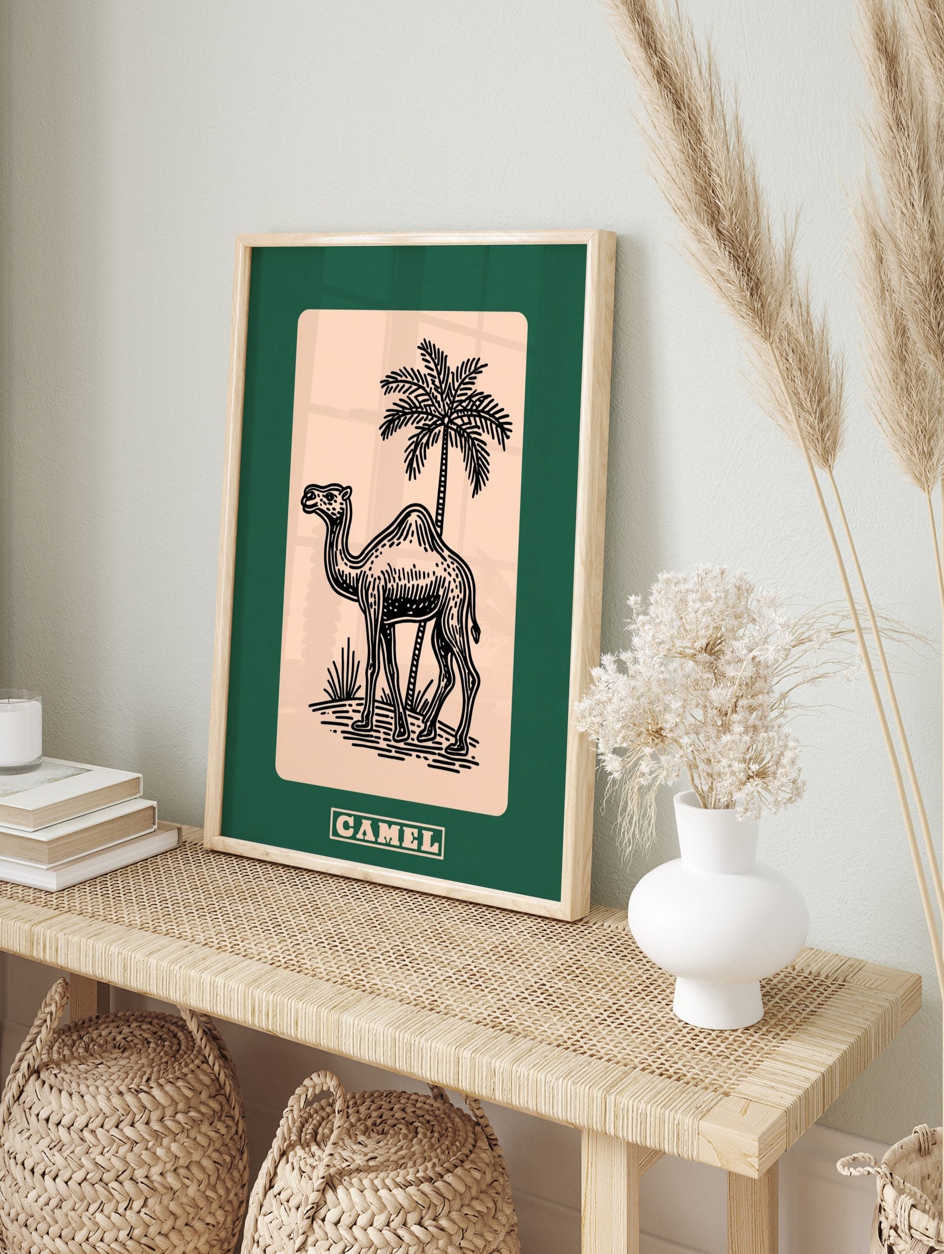 Black line art illustration of a camel and palm tree on beige, with a dark green border, in an alternate framed mockup