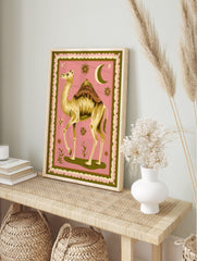 Illustrative camel with ornate saddle, crescent moon, and stars on pink background with green, in an alternate framed mockup