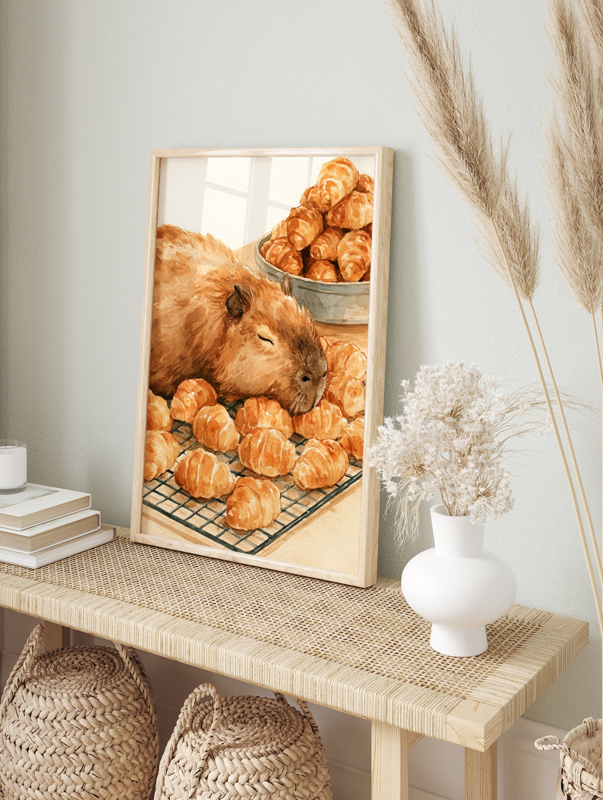 Watercolour illustration of a sleeping capybara resting on a wire rack filled with golden, in an alternate framed mockup