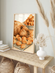 Watercolour illustration of a sleeping capybara resting on a wire rack filled with golden, in an alternate framed mockup