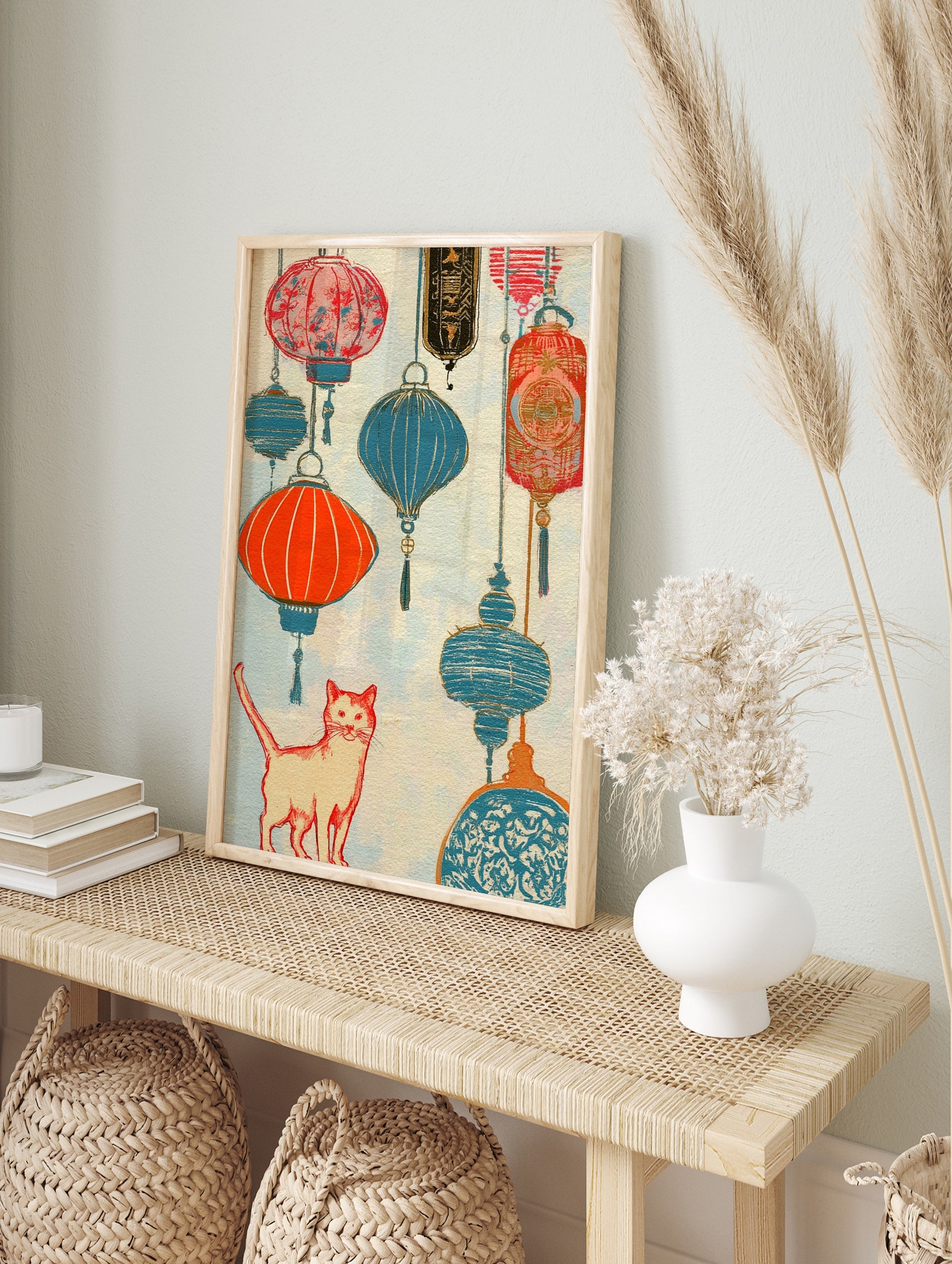 An orange cat stands below hanging red and blue paper lanterns in this vibrant, textured, in an alternate framed mockup