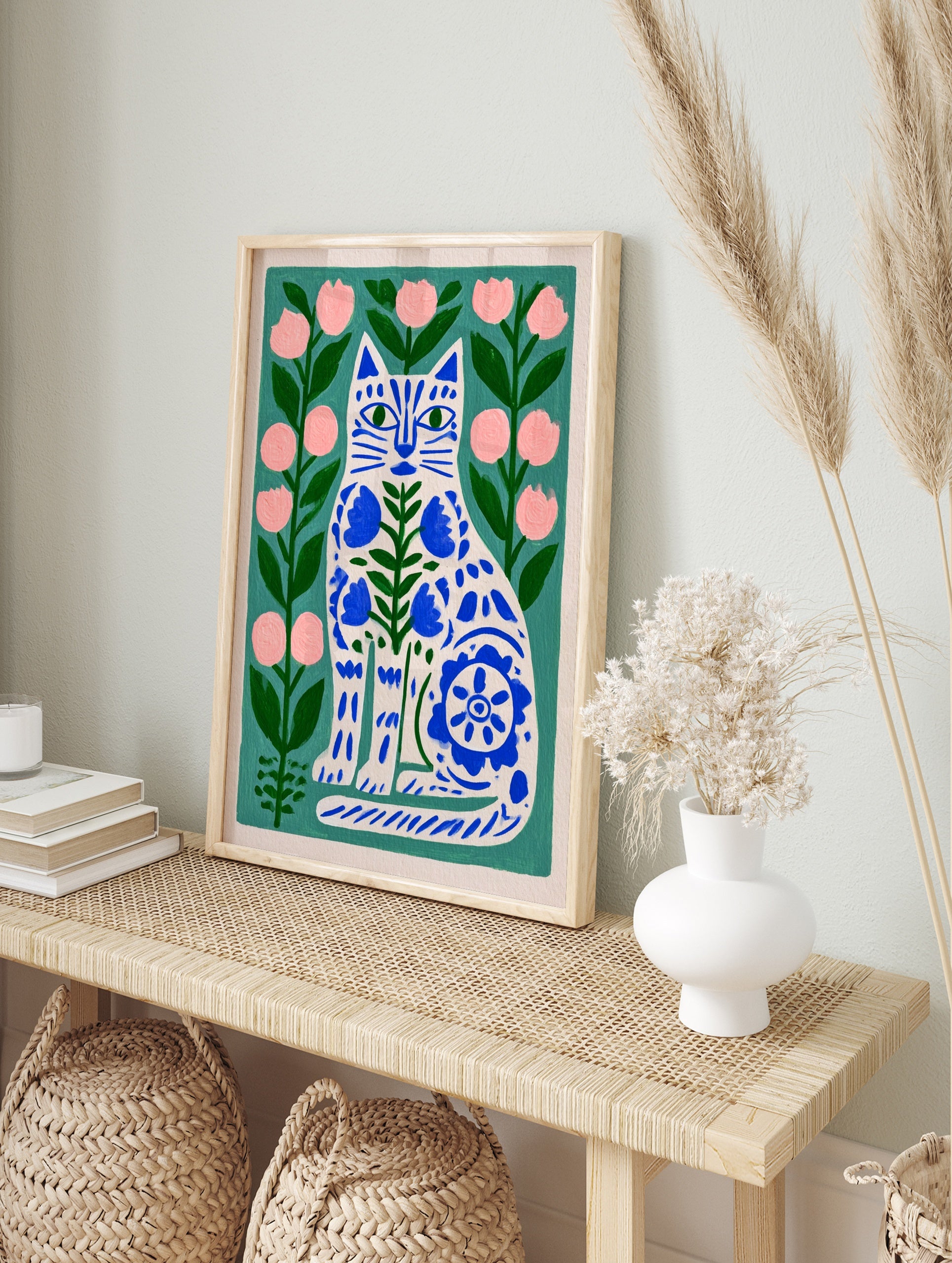 Illustrative cat wall art with blue folk-art floral patterns on a green background with pink, in an alternate framed mockup