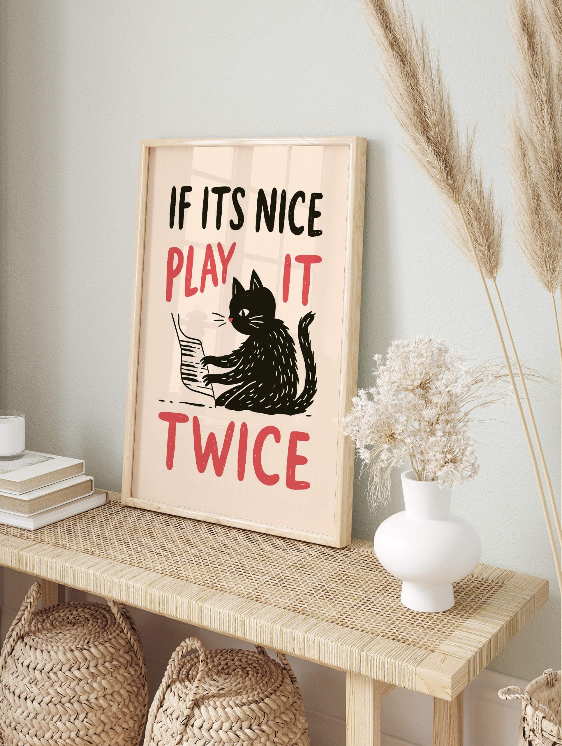 Illustrative wall art of a black cat playing the piano with red text reading IF ITS NICE PLAY, in an alternate framed mockup
