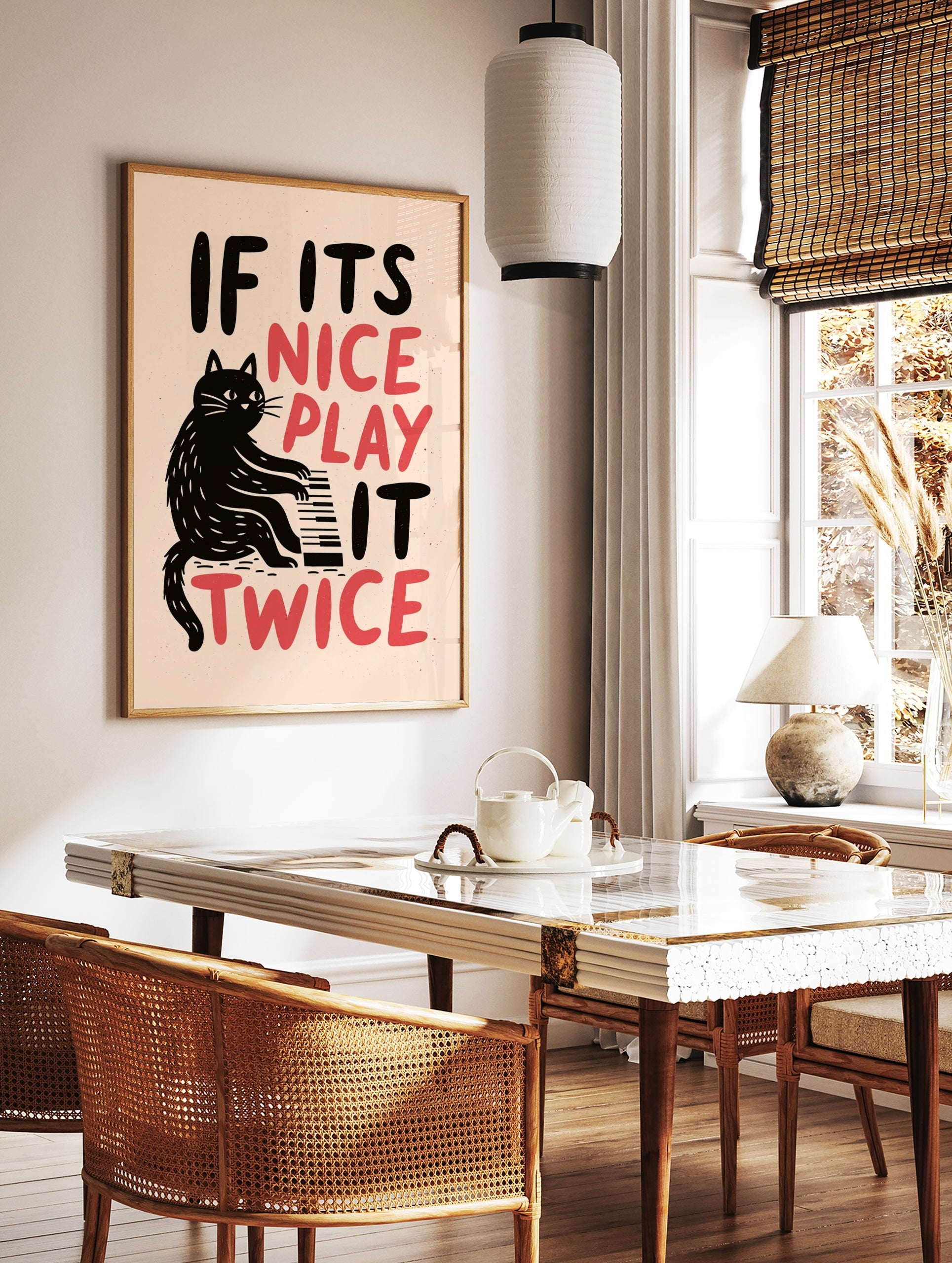 Black cat playing a piano illustration with the words IF ITS NICE PLAY IT TWICE in black and red on, in a styled room mockup