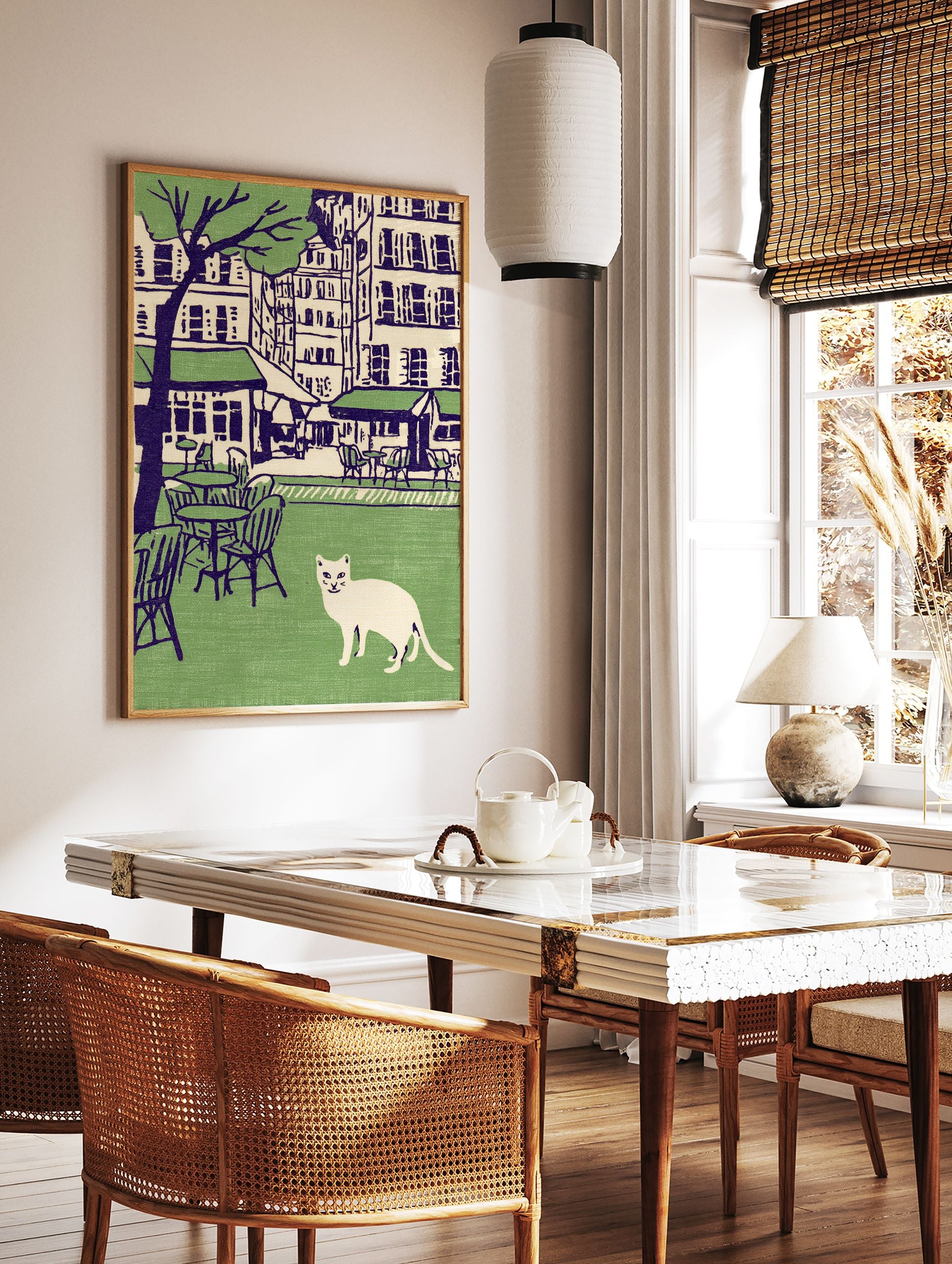 Illustration of a white cat in a green park with cafe tables, chairs, city buildings, and a tree in the background. Cat wall art. - Image 2