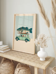Illustrative print of cats driving a light green vintage car with a large teal fish on the, in an alternate framed mockup