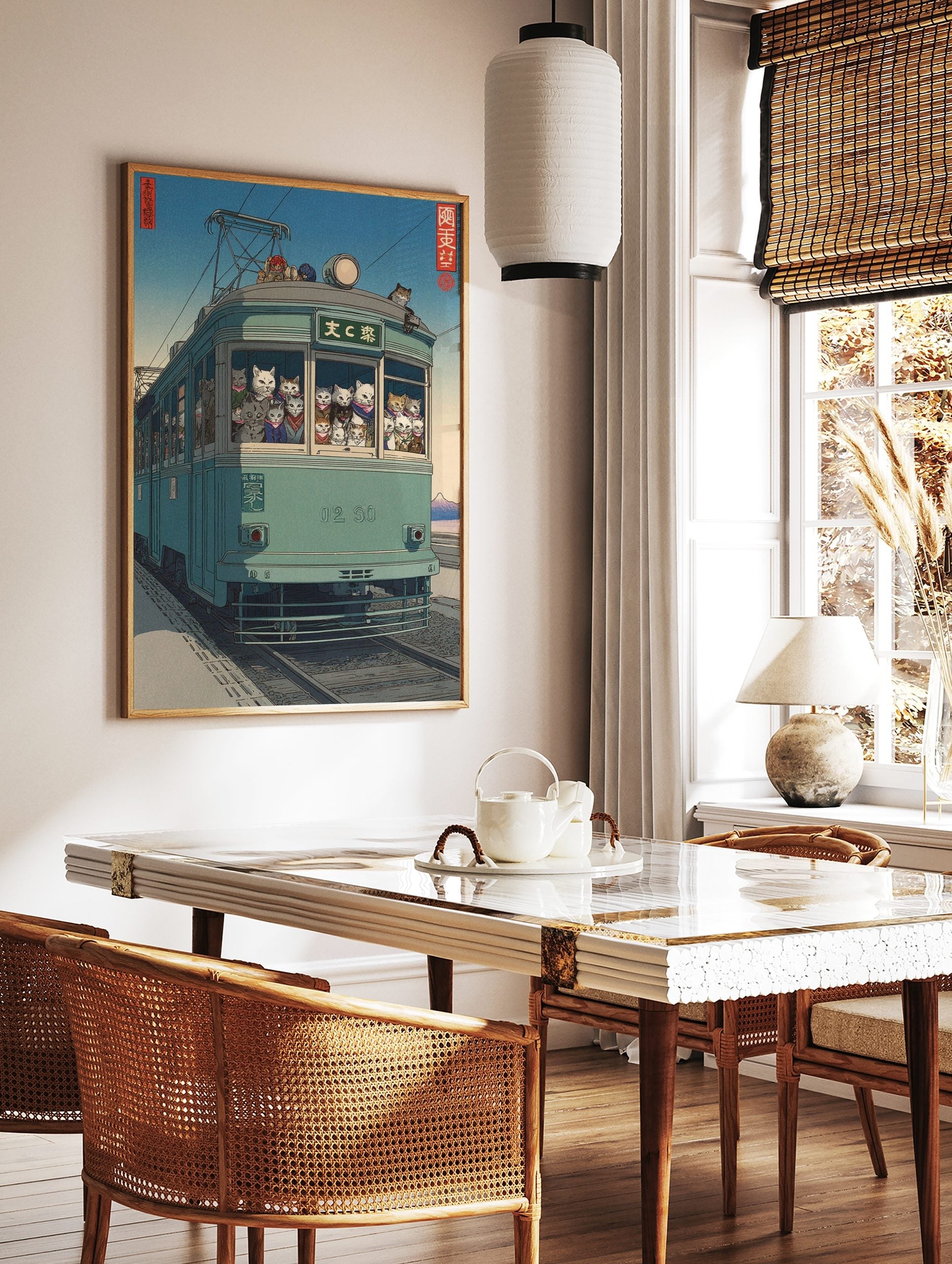 Japanese ukiyo-e style art print of cats riding a teal tram with distant mountain and blue sky, in a styled room mockup