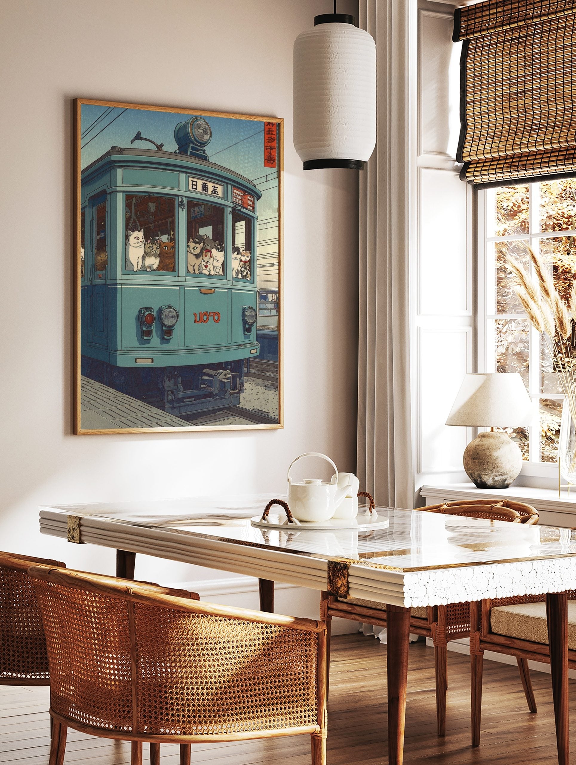 Illustrative print of numerous cats riding a teal-blue Japanese tram with visible Japanese text on, in a styled room mockup