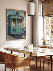 Illustrative print of numerous cats riding a teal-blue Japanese tram with visible Japanese text on, in a styled room mockup