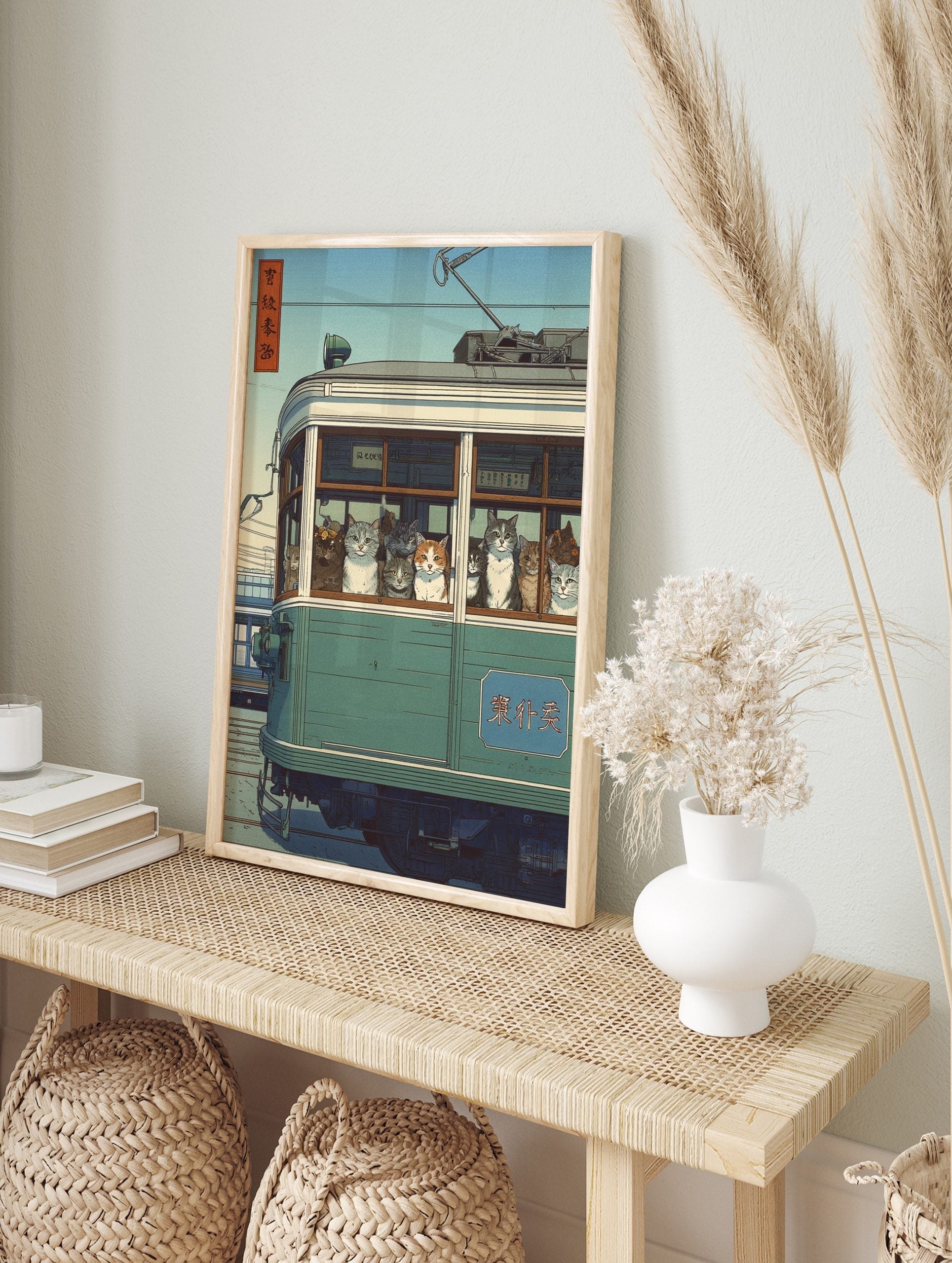 Japanese Ukiyo-e style print of many cats looking out from a green tram window under a blue, in an alternate framed mockup