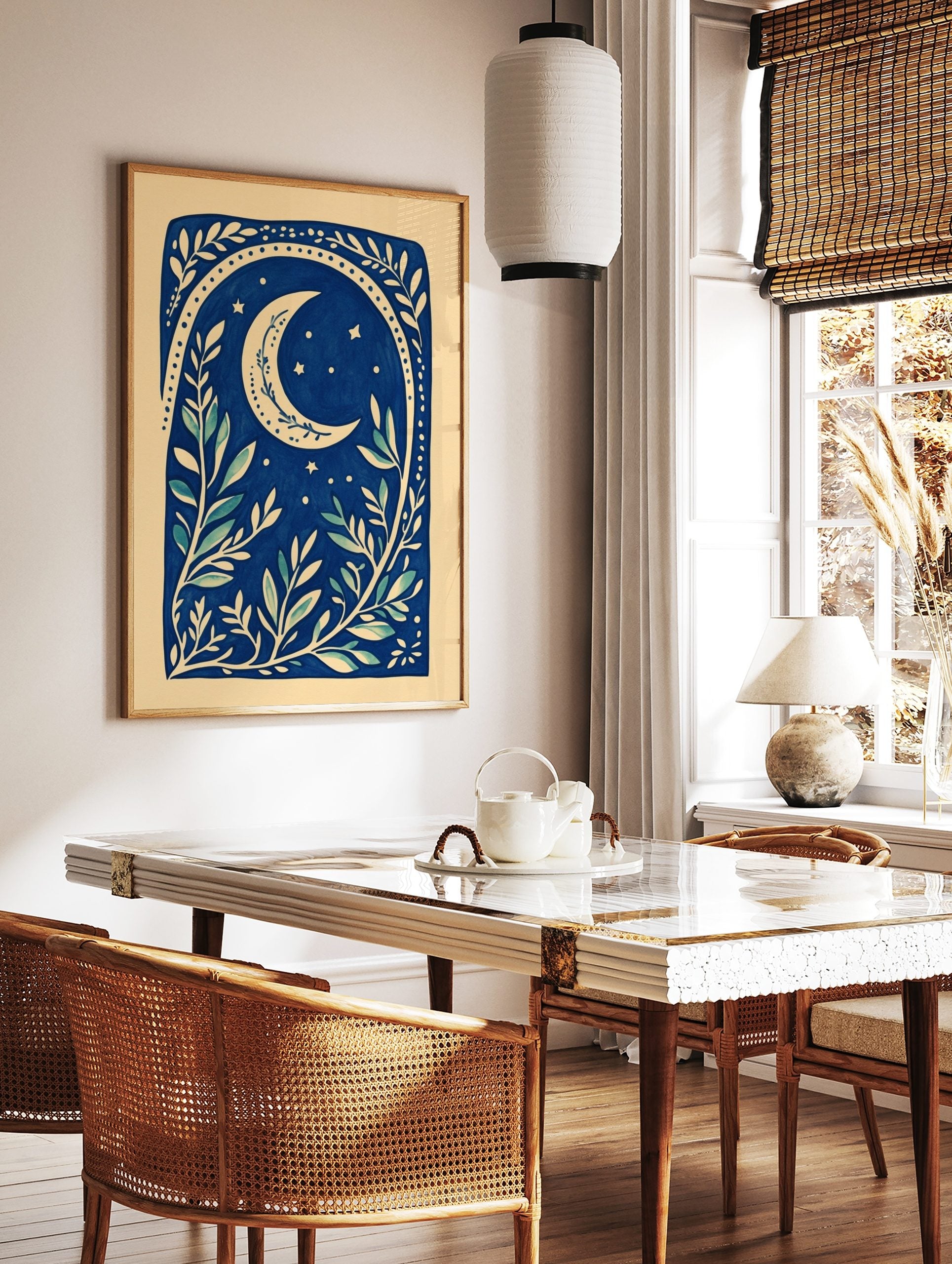 Illustrative deep blue botanical print with a cream crescent moon, stars, and leafy branches, in a styled room mockup