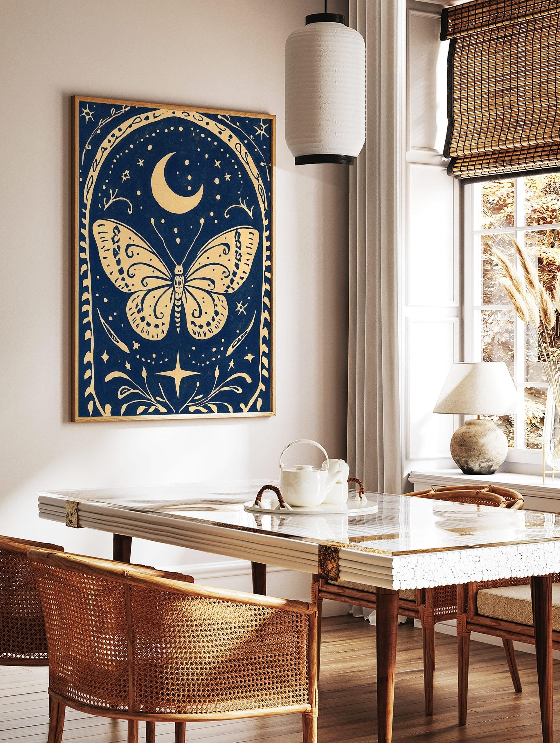 Illustrative celestial butterfly wall art with crescent moon, stars, and ornate border on a deep, in a styled room mockup
