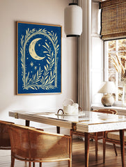 Illustrative cream crescent moon and stars with botanical foliage on a deep blue background, in a styled room mockup