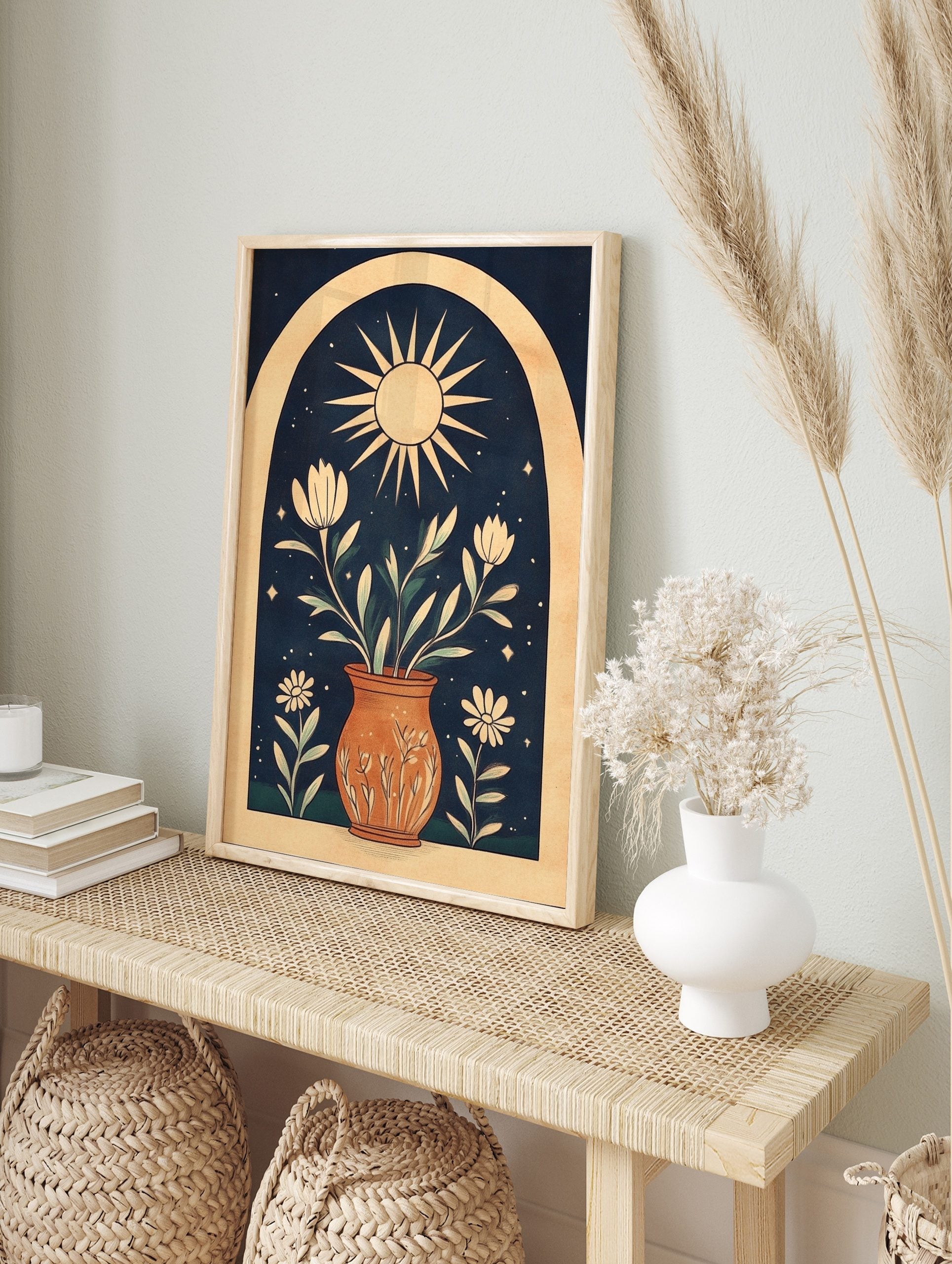 Illustrative wall art print with sun, potted white flowers, green leaves, stars, and arch on, in an alternate framed mockup