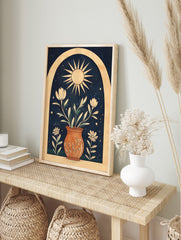 Illustrative wall art print with sun, potted white flowers, green leaves, stars, and arch on, in an alternate framed mockup
