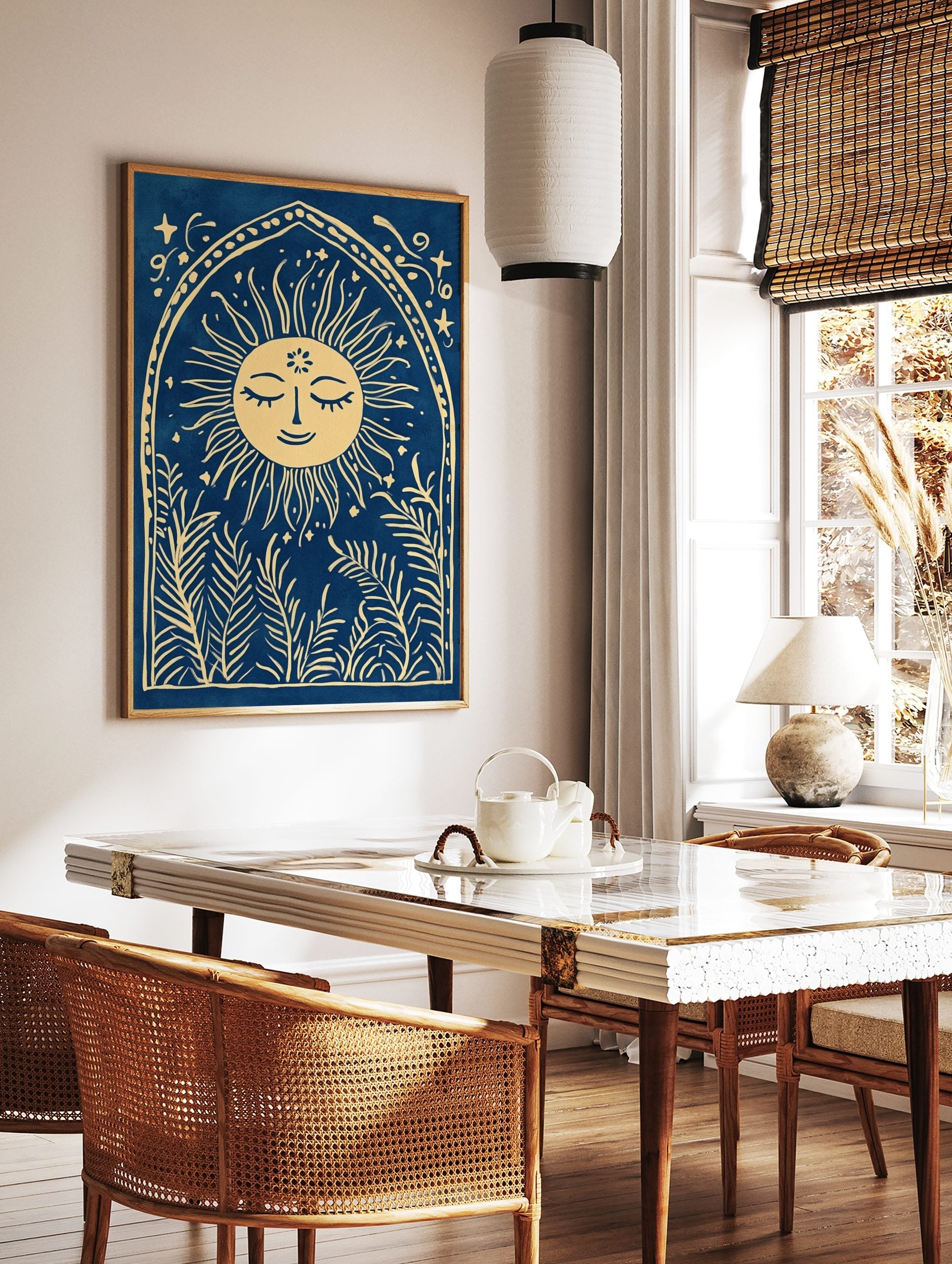 Illustrative print of a smiling sun with leafy plants in an arched frame on a blue background, in a styled room mockup