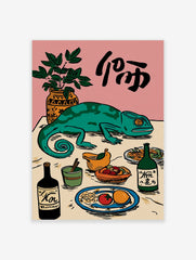 Illustrative wall art with a green chameleon on a table surrounded by a plant, bottles, fruit, and black calligraphy