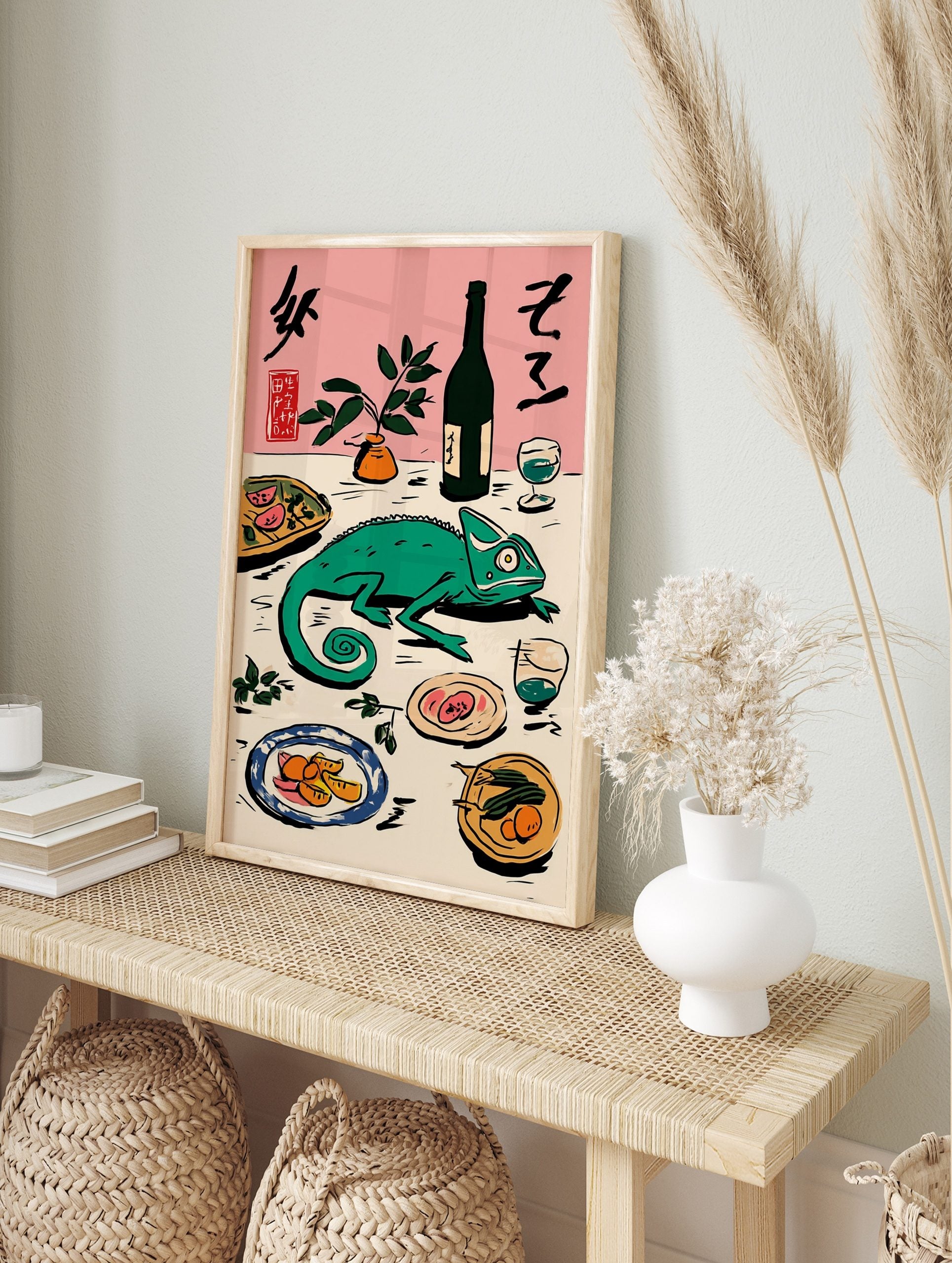 Green chameleon on a table with Japanese calligraphy, bottle, plant, and plates of food on a, in an alternate framed mockup