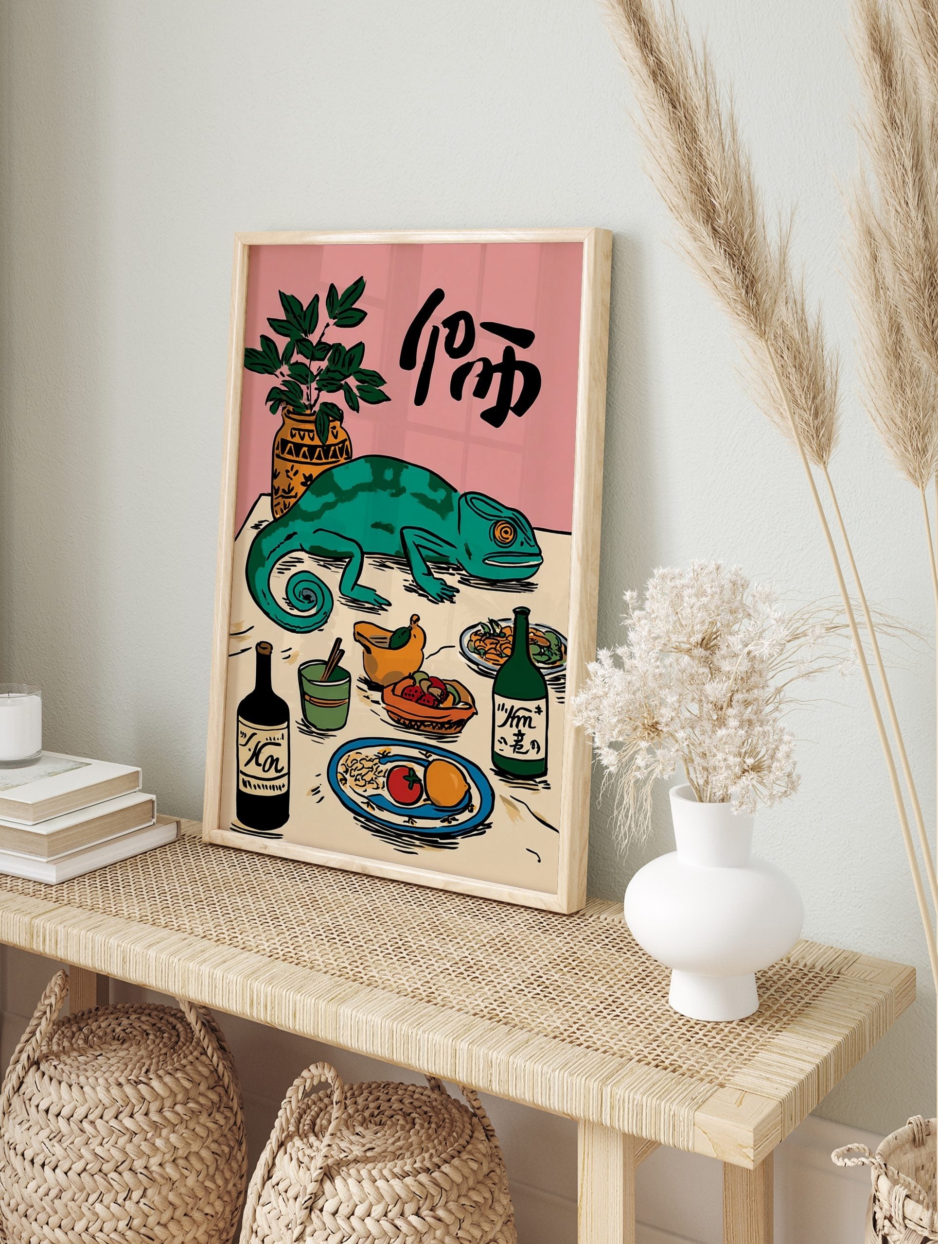 Illustrative green chameleon on a table with food, drinks, a plant, and Japanese characters, in an alternate framed mockup