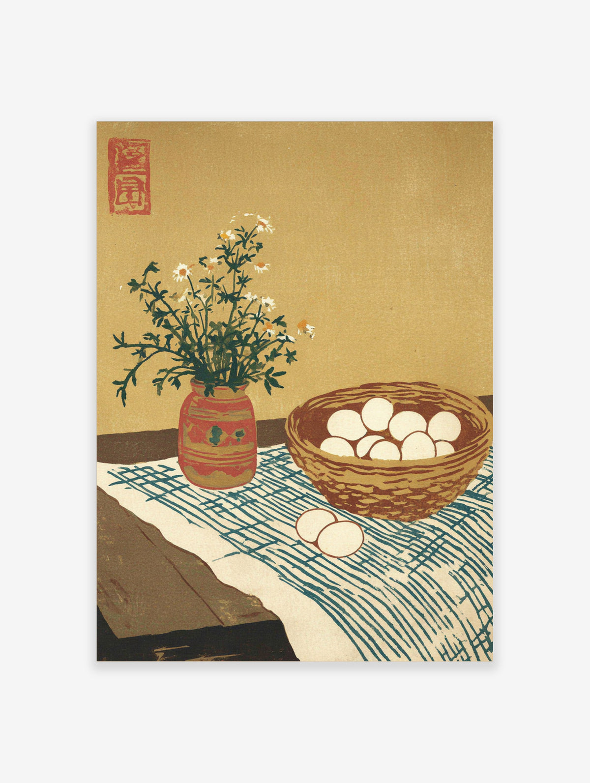 Chamomile flowers in a red vase beside a basket of eggs on a blue patterned cloth, beige background