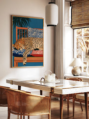 Illustration of a sleeping cheetah on a wooden bench with patterned cushions and palm leaves, in a styled room mockup