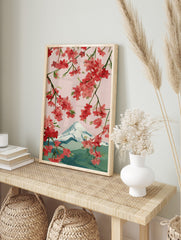 Illustrative cherry blossom branches with pink and red flowers framing snow-capped Mount Fuji, in an alternate framed mockup